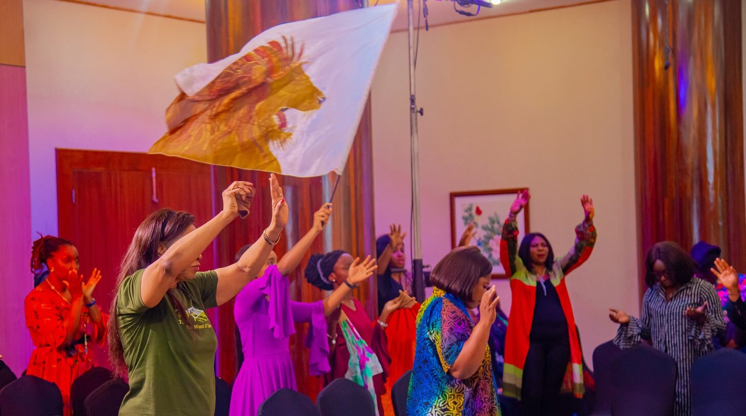 Worshipers dancing with silk flags during a GEM prophetic worship meeting